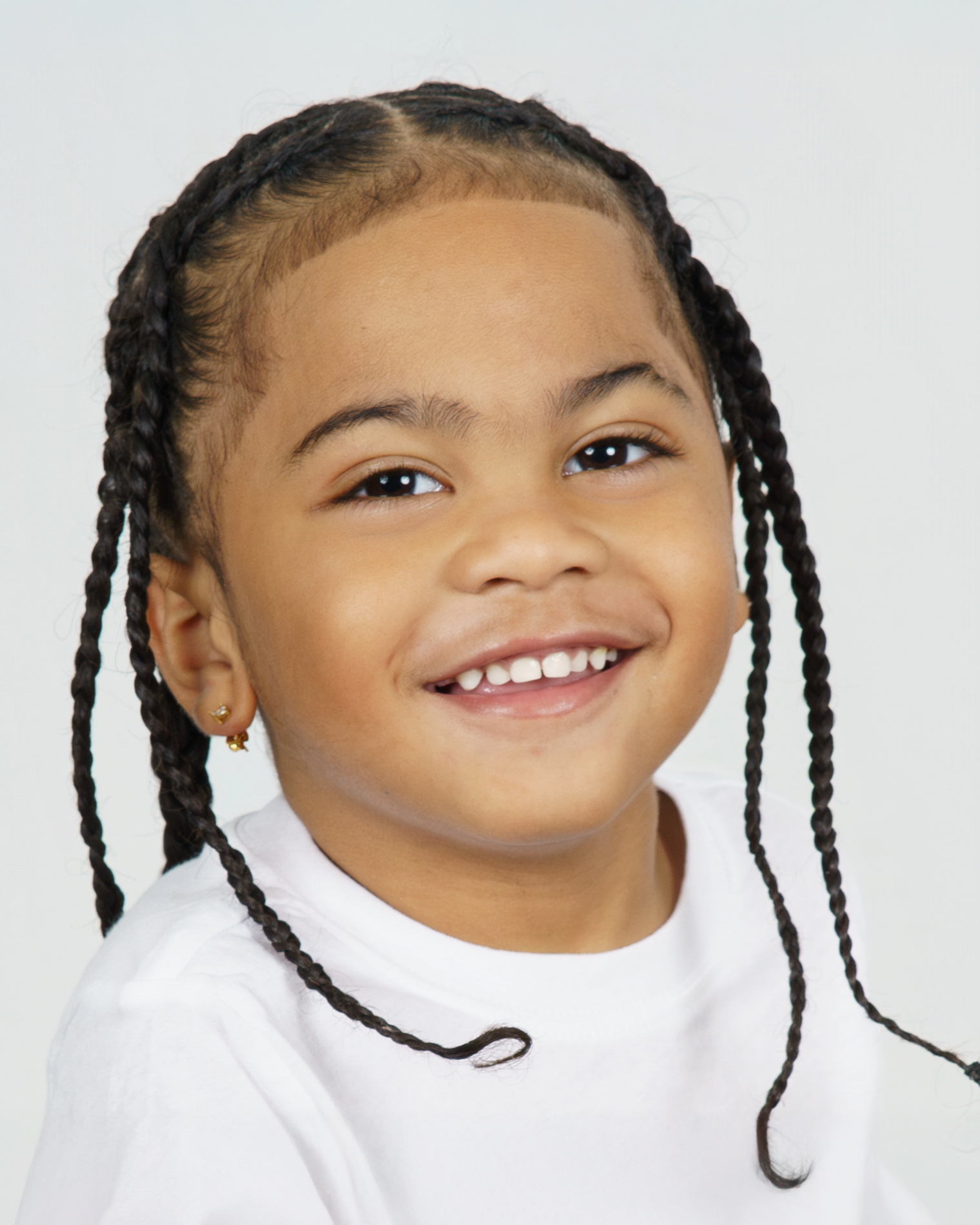 Studio portrait of twin boy smiling with braids